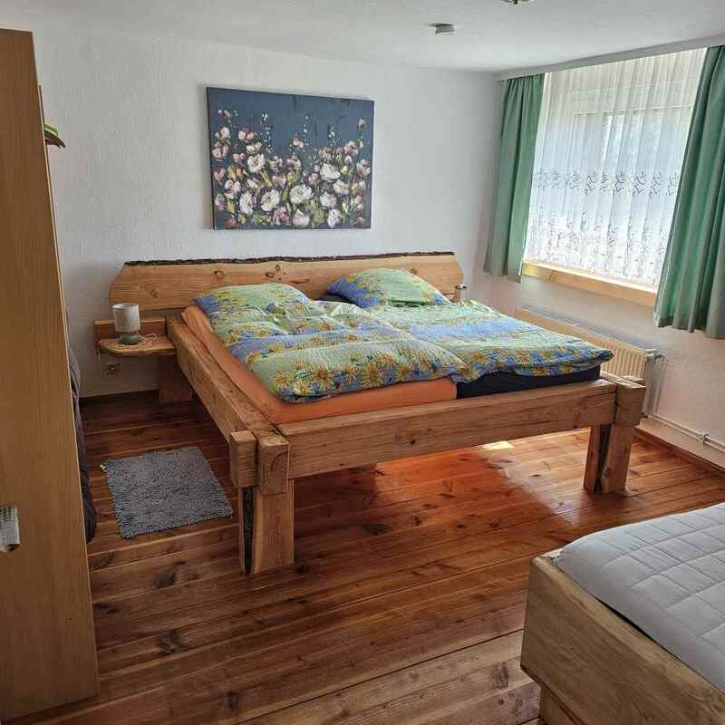 Schlafzimmer mit selbst gebauten Holzbett